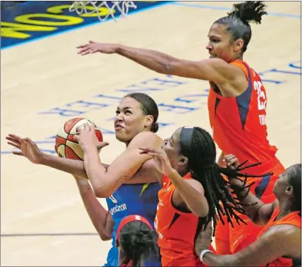  ?? LOUIS DELUCA/THE DALLAS MORNING NEWS/AP PHOTO ?? Dallas Wings center Liz Cambage (8) tries to shoot despite the defense of several Connecticu­t Sun players in the fourth quarter of Sunday’s WNBA game at Arlington, Texas. The Sun won 92-75.