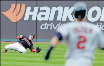  ?? [TONY DEJAK/THE ASSOCIATED PRESS] ?? The Indians’ Brandon Guyer, left, makes the sliding grab on a ball hit by the Twins’ Brian Dozier in the first inning.