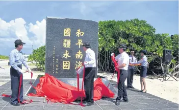  ?? EPA ?? Interior Minister Chen Wei-zen unveils a tablet claiming Taiwan’s sovereignt­y over Taiping island in the South China Sea on Saturday. It bears the words of President Ma Ying-jeou: ‘Peace in the South China Sea and Our National Territory Secure Forever’.