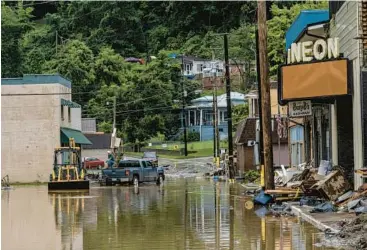  ?? JON CHERRY/THE NEW YORK TIMES ?? Workers clear debris from a flooded street Monday in Fleming-Neon, Kentucky.