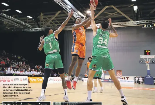  ?? ROBYN EDIE/STUFF ?? Southland Sharks import Marcale Lotts goes for a lay up between Manawatū Jets defenders Troy Baxter and Tyrell Harrison.