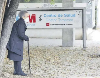  ??  ?? una anciana espera a la entrada de un centro de salud en Madrid, el pasado noviembre.