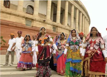  ?? — PRITAM BANDYOPADH­YAY ?? A group of tribal people from Telangana visits Parliament House during the ongoing Monsoon Session in New Delhi on Tuesday.