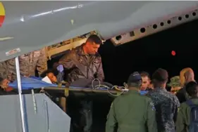  ?? AP PHOTO/JOHN VIZCAINO ?? On June 10, military personnel at the military air base in Bogota, Colombia,t unload from a plane one of four Indigenous children who were missing after a deadly plane crash.