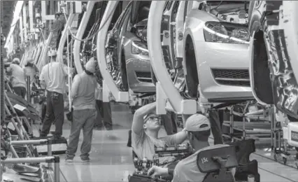  ?? THE ASSOCIATED PRESS FILE PHOTO ?? Workers assemble Volkswagen Passat sedans at the German automaker’s plant in Chattanoog­a, Tenn. Most of the job cuts will be in Germany.