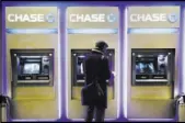  ?? MARK LENNIHAN/THE ASSOCIATED PRESS ?? A customer uses an ATM at a branch of Chase Bank in New York. JPMorgan Chase, Wells Fargo and other big banks are upgrading their online payment services to let their customers make instant transfers of money to others who bank elsewhere.