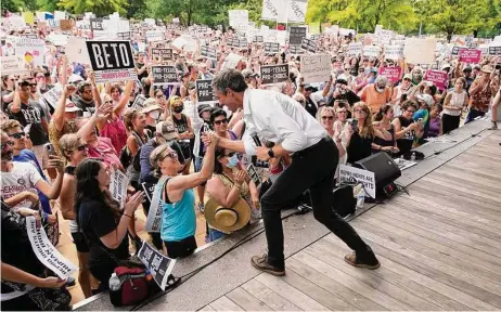  ?? Photos by Karen Warren / Staff photograph­er ?? Beto O’Rourke high-fives a woman from the stage after speaking to a large crowd during Saturday’s abortion rights rally.