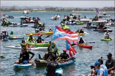  ?? The Associated Press ?? AQUATIC PROTEST: Demonstrat­ors in kayaks gathered in front of La Fortaleza for an aquatic protest against Puerto Rico Gov. Ricardo Rossello on Sunday in San Juan, Puerto Rico. Rossello said Sunday evening that he will not resign in the face of public furor over an obscenity-laced leaked online chat, but he will not seek re-election or continue as head of his pro-statehood political party.