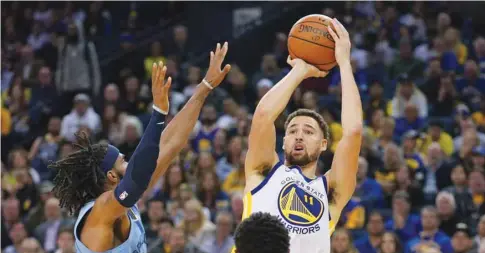  ?? (USA TODAY Sports) ?? Golden State Warriors’ Klay Thompson (right) shoots the basketball against Memphis Grizzlies’ Mike Conley during the game in Oakland on Monday.