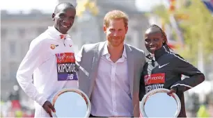  ?? AFP ?? Britain’s Prince Harry (centre) poses with elite men’s race winner Kenya’s Eliud Kipchoge (left) and women’s champion Kenya’s Vivian Cheruiyot during the trophy ceremony in London. —