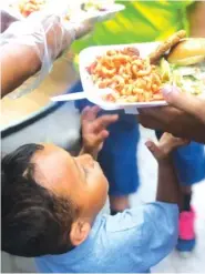  ?? AP FILE PHOTO/DANIELA DOMINGUEZ ?? A child reaches for a meal cooked by a team from the Bay Area Border Relief at a tent encampment in Matamoros, Mexico.