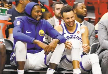  ?? Joe Skipper / Associated Press ?? Kevin Durant and Stephen Curry had plenty of time to relax during the Warriors’ blowout win in Miami.