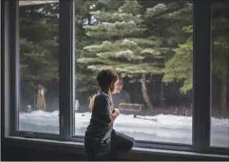  ??  ?? Lucas Parobek, 8, looks at his family’s melting homemade ice rink.