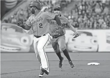  ?? PHOTOS BY JEFF CHIU/AP ?? Giants baserunner Denard Span is chased by Diamondbac­ks shortstop Adam Rosales before being tagged out during the first inning of Friday night’s game in San Francisco.