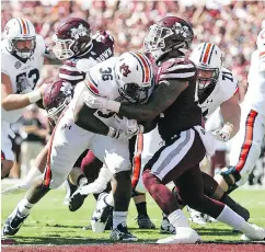  ?? JAMES PUGH / THE CHRONICLE VIA AP FILES ?? Mississipp­i State defender Leo Lewis, wearing maroon, told the NCAA he received free merchandis­e from a clothing store while on recruiting trips to Ole Miss, something that would violate NCAA rules.