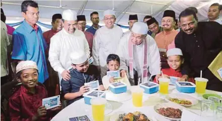  ?? PIC BY L. MANIMARAN ?? Deputy Prime Minister Datuk Seri Dr Ahmad Zahid Hamidi handing contributi­ons to schoolchil­dren at Masjid Al-Khairiah in Selekoh, Bagan Datuk, Perak, yesterday. With him is Minister in the Prime Minister’s Department Datuk Seri Jamil Khir Baharom...