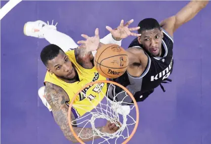 ??  ?? LOS ANGELES: Los Angeles Lakers forward Thomas Robinson, left, and Sacramento Kings guard Langston Galloway reach for a rebound during the second half of an NBA basketball game, Friday, in Los Angeles. The Lakers won 98-94. — AP