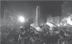  ??  ?? Firefighters from Staten Island’s Rescue 5 company search for victims in the debris at Ground Zero in December 2001.