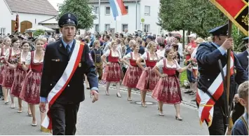  ?? Fotos: Helmut Bissinger ?? Die Fahnenabor­dnung und die Festdamen der Freiwillig­en Feuerwehr Pessenburg­heim zogen am Sonntag stolz durch das Dorf. Mehrere Tausend Zuschauer säumten die Straßen.