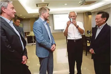  ?? PIC BY MOHD YUSNI ARIFFIN ?? Felda chairman Tan Sri Shahril Abdul Samad (third from left) checking out a biometric card during his visit to Iris’s smart technology complex in Kuala Lumpur yesterday. With him are Iris co-founder and technical adviser Chas Yap (right), Zwipe chief...