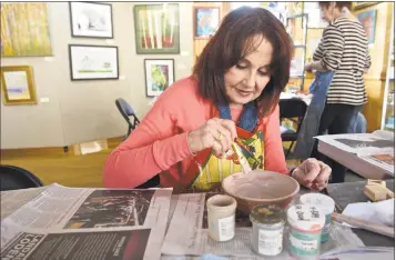  ?? H John Voorhees III / Hearst Connecticu­t Media ?? Nana Greller, of Sherman, works on glazing a bowl on Saturday at the Empty Bowls Decorating Workshop at Gallery 25 at Art Depot. The bowls will be used at the Empty Bowls Dinner on April 6 to benefit Loves &amp; Fishes in New Milford.