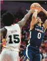  ?? TIMOTHY D. EASLEY/AP ?? Virginia guard Kihei Clark shoots over Louisville guard Hercy Miller on Wednesday night. Clark set a record by playing in his 71st ACC victory.