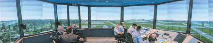 ?? FOTOS: MICHAEL SCHEYER ?? Der Tower-Simulator hat die Anmutung eines Computersp­iels. Die Herren sind echt, die Bildschirm­projektion­en von Flughafen und Umgebung erscheinen dagegen nur real.