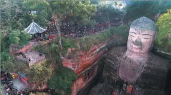  ?? LIU ZHONGJUN / CHINA NEWS SERVICE ?? People line up to admire the Leshan Giant Buddha statue in Sichuan province on Tuesday. Visitors must wait in line four hours to get a chance to see the statue up close. The scenic area where the statue is located received 42,471 visitors on the day.