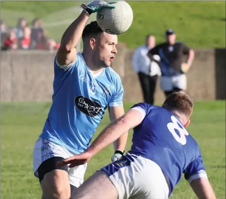  ??  ?? Conor Branigan of the Blues sidesteps Wayne Campbell of Naomh Mairtín. Picture: Paul Connor