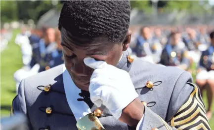  ??  ?? West Point Class President Joshua Phillips wipes a tear during his commenceme­nt ceremony on Saturday.