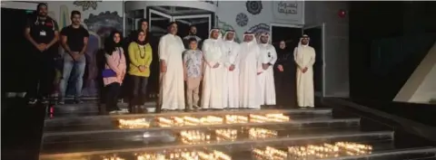  ??  ?? Citizens join EPA officials in lighting candles outside EPA building to mark the Earth Hour.