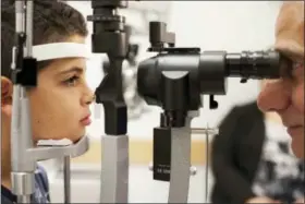  ?? BILL WEST — ASSOCIATED PRESS FILE PHOTO ?? In this Oct. 4, 2017, file photo, Dr. Albert Maguire, right, checks the eyes of Misa Kaabali, 8, at the Children’s Hospital of Philadelph­ia. Misa was 4-years-old when he received his gene therapy treatment. The first-of-its kind genetic treatment for...