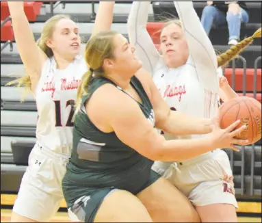  ?? RICK PECK/
SPECIAL TO MCDONALD COUNTY PRESS ?? McDonald County’s Megan Elwood
(left) and Adasyn Leach defend Mount Vernon’s Lisa Kruger during the Lady Mustangs’ 84-32 loss on Feb. 19 at MCHS.