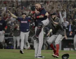  ?? JAYNE KAMIN-ONCEA / USA TODAY SPORTS ?? Boston Red Sox catcher Christian Vazquez leaps into the arms of pitcher Chris Sale as their teammates pour onto the field after the American League champions defeated the Los Angeles Dodgers, 5-1, in Game 5 to win the baseball World Series at Dodger Stadium on Sunday.