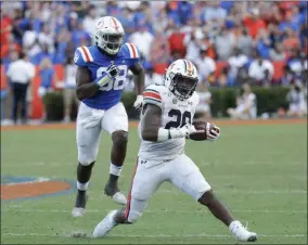  ?? JOHN RAOUX - THE ASSOCIATED PRESS ?? Auburn running back JaTarvious Whitlow (28) gets past Florida defensive lineman Luke Ancrum (98) for yardage during the second half of an NCAA college football game, Saturday, Oct. 5, 2019, in Gainesvill­e, Fla.