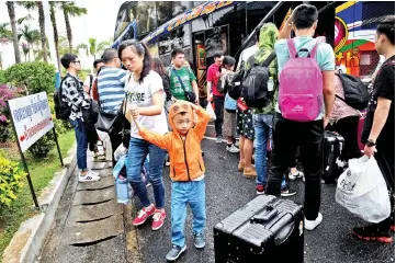  ??  ?? Chinese tourists disembark at Surat Thani airport after tour operators were forced to suspend boats to tourist islands. — AFP photo