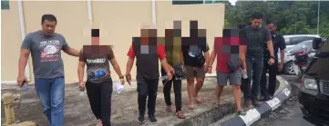  ??  ?? All the suspects being taken by police personnel to the Limbang Central Police Station.