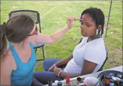  ??  ?? BOTTOM LEFT: Kristi Kent, the communicat­ions director for the city of Rome, paints 13-year-old Cedartown resident Lazaria Peters’ face.