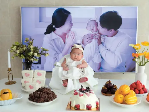  ??  ?? Lee Dong-kil’s daughter Lee Yoon-seol sits to celebrate the 100th day of her birth at Lee’s house in Daejeon, South Korea. Just two hours after she was born on New Year’s Eve, 2019 was ushered in, and the infant became 2 years old. — IC