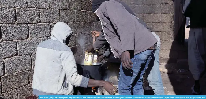  ??  ?? BANI WALID, Libya: African migrants prepare food at a Safe House in the town of Bani Walid, on the edge of the desert 170 kilometers southeast of the Libyan capital Tripoli. For migrants who escape torture and starvation at the hands of people...