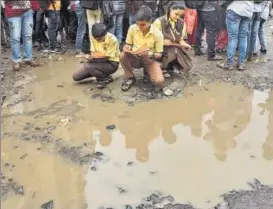  ?? SATISH BATE/HT PHOTO ?? Students of Sane Guruji School paint potholes in Santacruz on Saturday, as part of an agitation against the government’s indifferen­ce towards the condition of Mumbai’s roads.