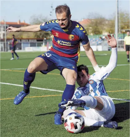  ??  ?? Ricard Pujol trata de robar el balón ante el jugador del Llagostera Pere Martínez.
