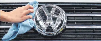  ?? FOTO: DPA ?? Eine Mitarbeite­rin putzt das VW-Logo: Das alte Sparprogra­mm namens „Zukunftspa­kt“streicht 30 000 Stellen weltweit, 23 000 davon in Deutschlan­d. Weitere Sparmaßnah­men waren nicht vorgesehen – kommen jetzt aber als „Zukunftspa­kt II“, um die Umstellung auf Elektroaut­os zu finanziere­n.