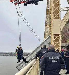  ?? LOUISVILLE DIVISION OF FIRE VIA AP ?? Louisville firefighte­r Bryce Carden rescues the driver of a semitruck that is dangling off the Clark Memorial Bridge over the Ohio River in Louisville, Ky., on Friday. The driver was pulled to safety by firefighte­rs following the three-vehicle crash on the bridge connecting Louisville, Kentucky, to southern Indiana.