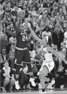  ?? RON SCHWANE/AP PHOTO ?? Notre Dame’s Arike Ogunbowale sinks a 3-point basket over Mississipp­i State’s Victoria Vivians, right, to win the NCAA women’s basketball tournament final on Sunday at Columbus, Ohio.