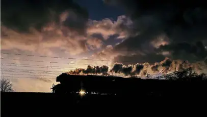  ??  ?? Flying Scotsman’s distinctiv­e German-type smoke deflectors are evident as No. 60103 is silhouette­d by the setting sun passing Mancetter on the outskirts of Atherstone on the West Coast Main Line with the 5Z78 10am East Lancashire Railway to Alton locomotive and support coach movement on February 11. GRAHAM NUTTALL