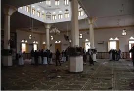  ?? FOTO: EPA / AHMED HASSAN ?? Människor står inne i moskén efter attentatet. En tredagars landssorg har blivit utlyst.