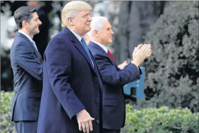 ?? AP PHOTO ?? U.S. President Donald Trump walks with Vice-President Mike Pence and House Speaker Paul Ryan, R-Wis., for an event after final passage of the tax overhaul plan, on the South Lawn of the White House Wednesday.