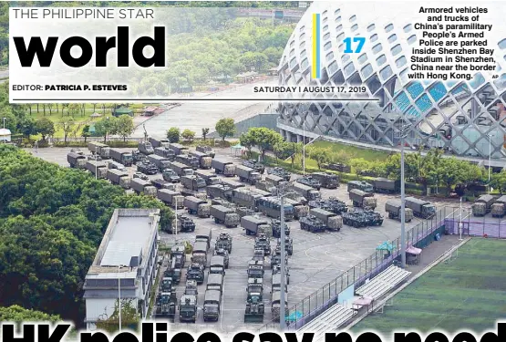  ?? AP ?? Armored vehicles and trucks of China’s paramilita­ry People’s Armed Police are parked inside Shenzhen Bay Stadium in Shenzhen, China near the border with Hong Kong.