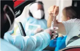  ?? MIKE STOCKER/SOUTH FLORIDA SUN SENTINEL ?? Healthcare workers collect samples at a COVID-19 testing site at the Miami-Dade County Auditorium in Miami.